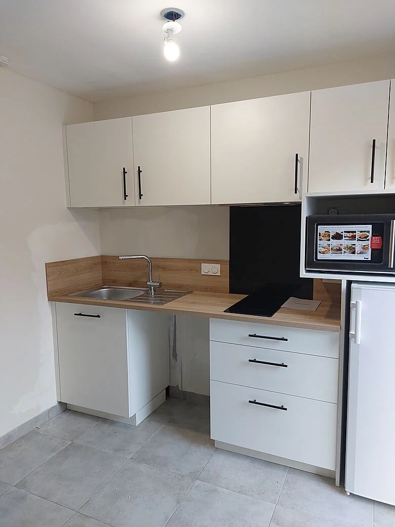 Kitchenette blanche avec plan de travail bois